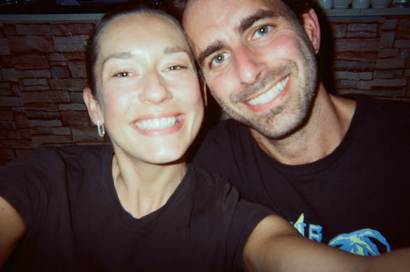 Tess smiling in a film-camera selfie with a friend